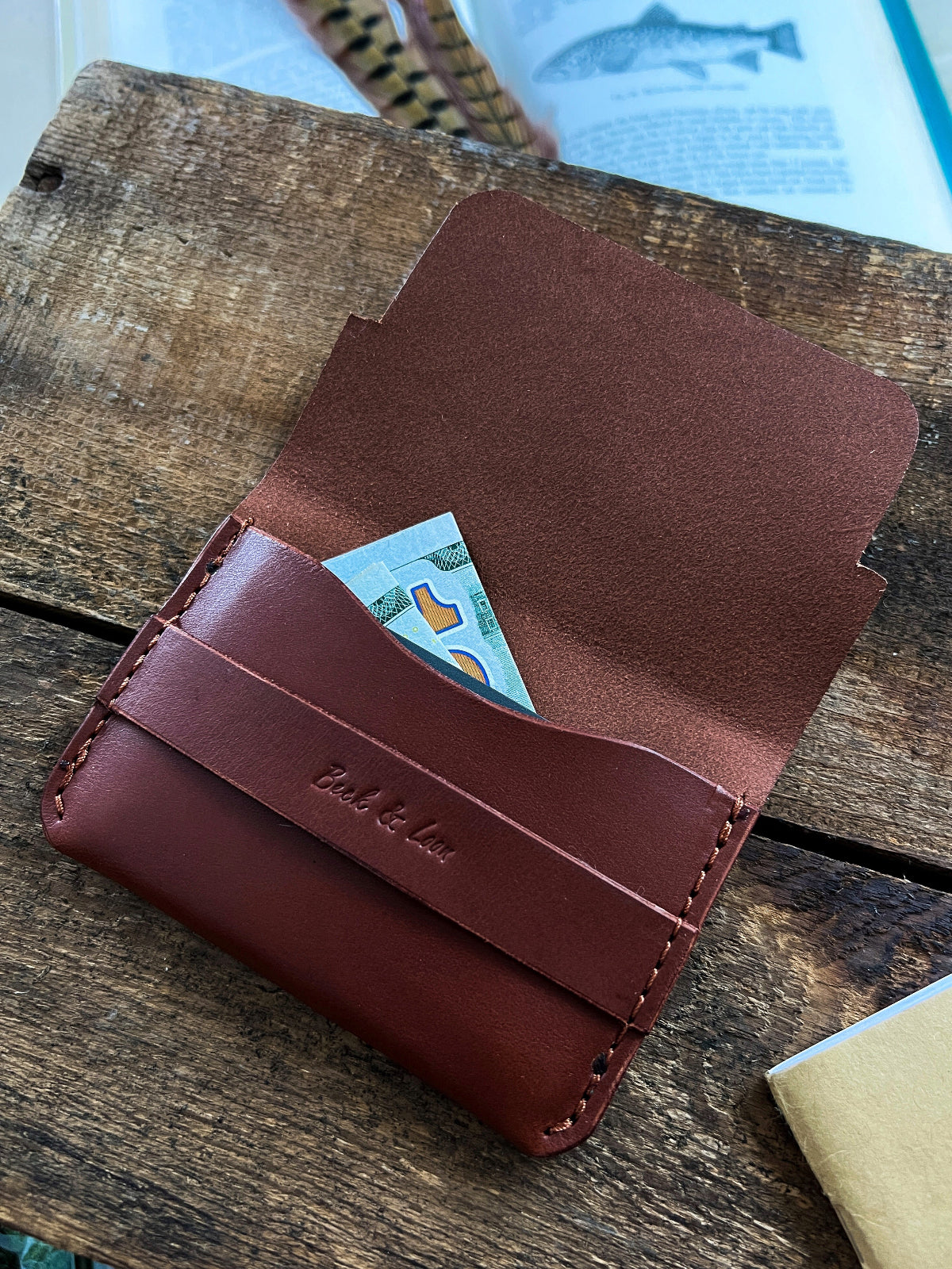 hand brown leather wallet with cash and cards in it
